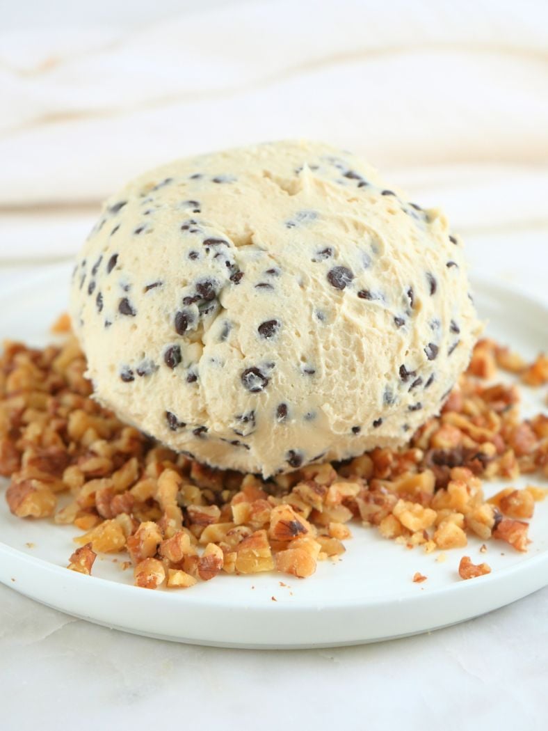 Chocolate chip cheese ball on a plate of chopped walnuts