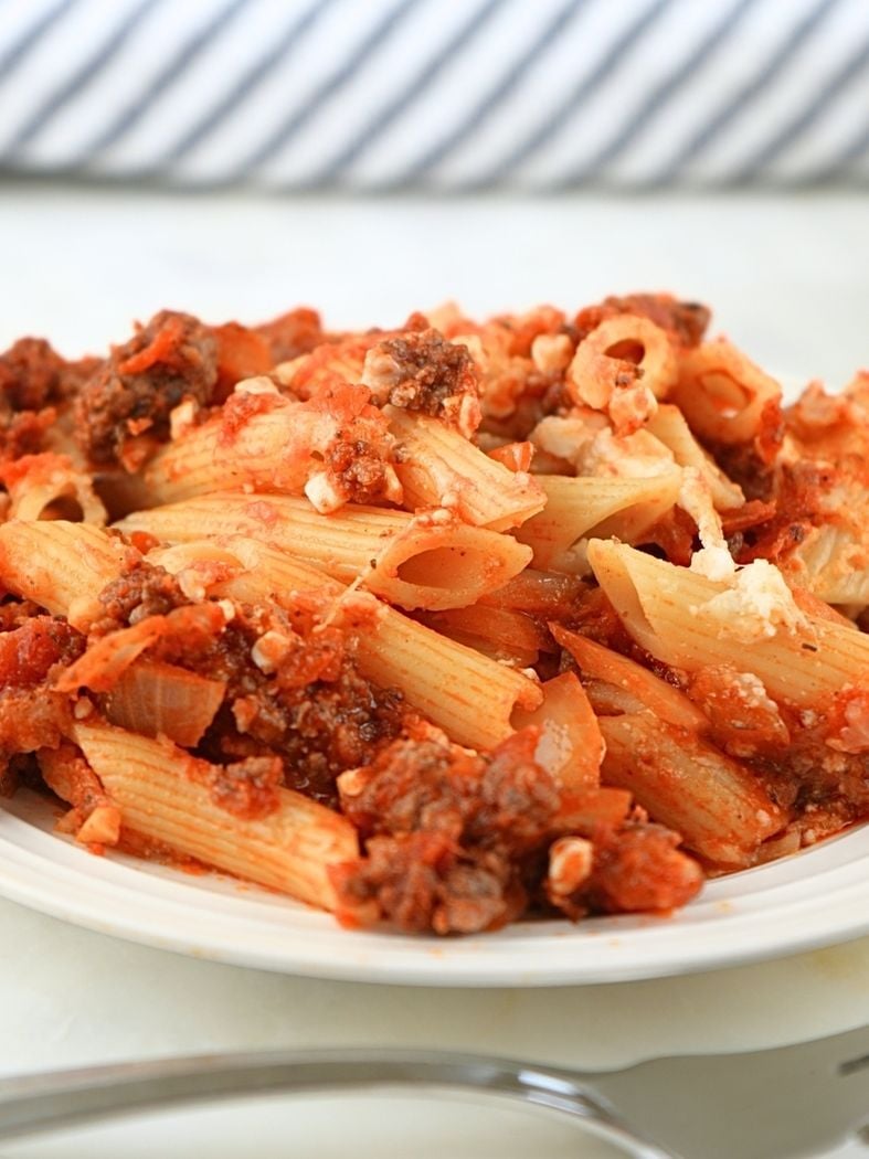 A white plate with a serving of a cooked baked ziti freezer meal.
