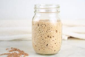 A mason jar with active einkorn sourdough starter, shown with einkorn wheat berries