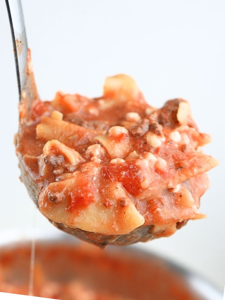 A ladle filled with slow cooker lasagna soup