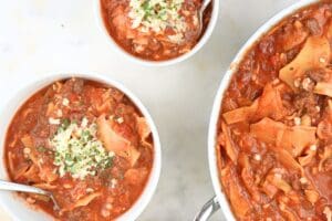 Bowls of slow cooker lasagna soup next to a large pot