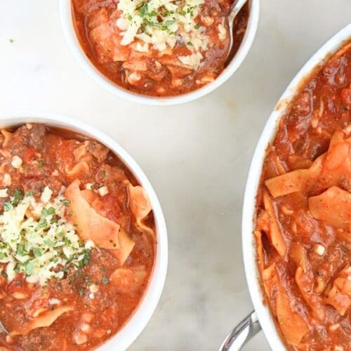 Bowls of slow cooker lasagna soup next to a large pot