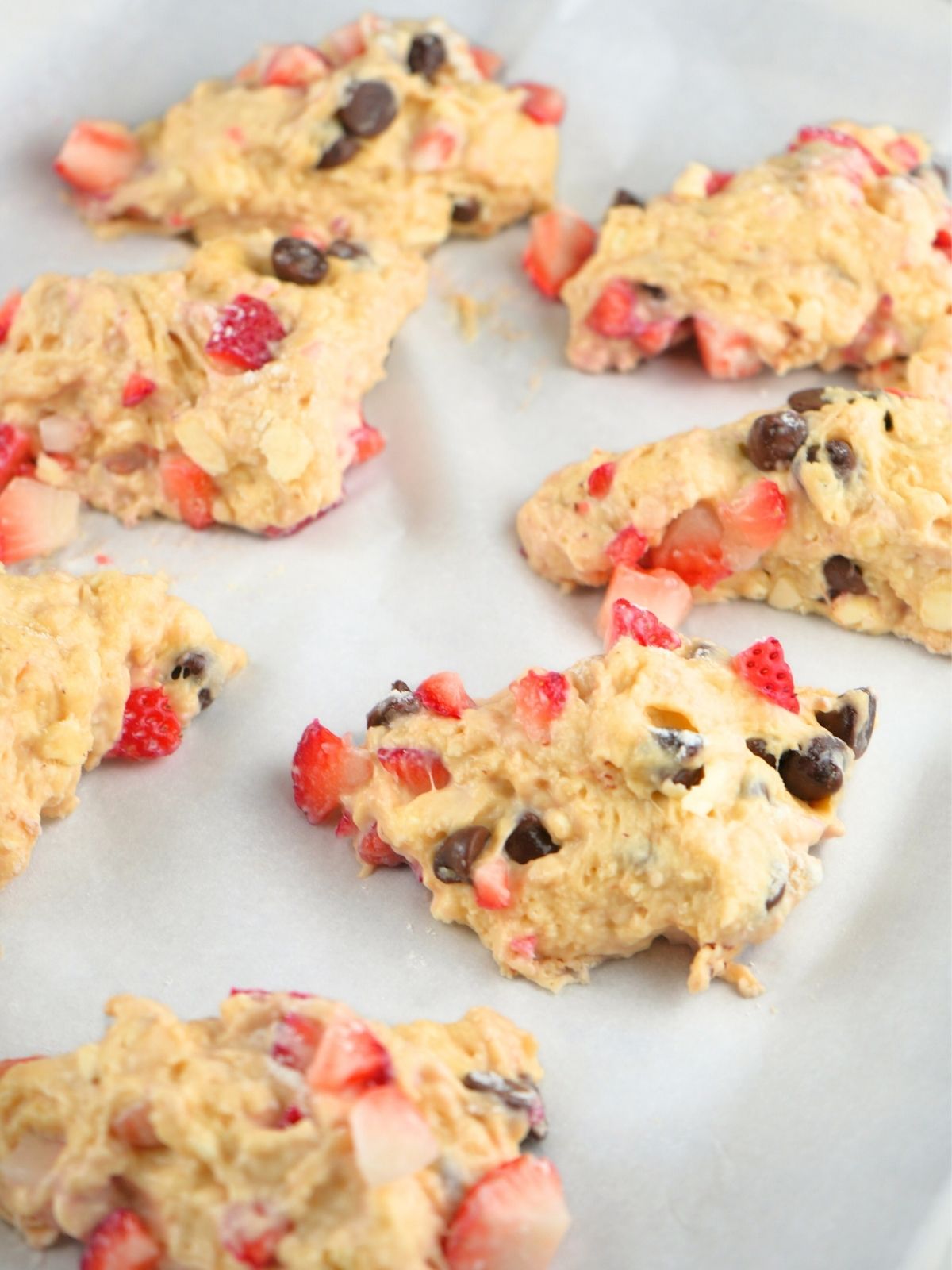 Scone dough divided into wedges and on parchment paper.