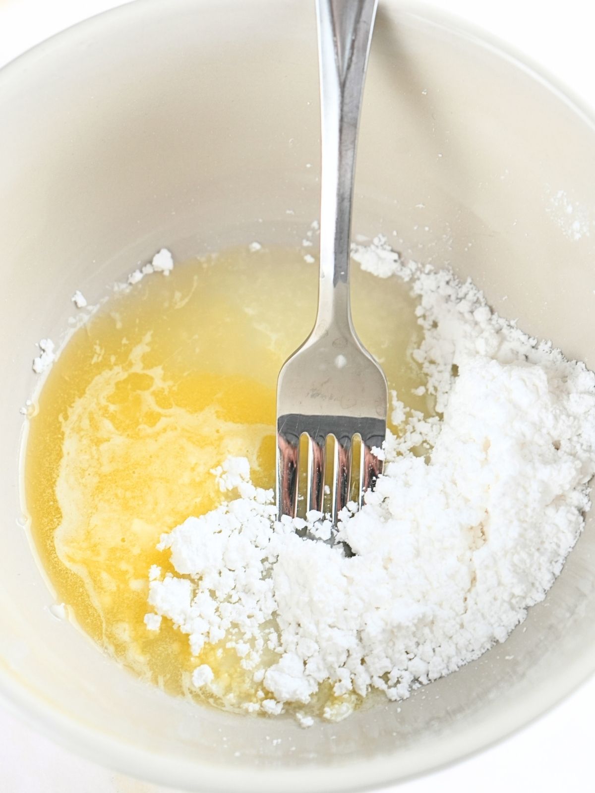 Lemon glaze ingredients in a bowl, shown with a fork.