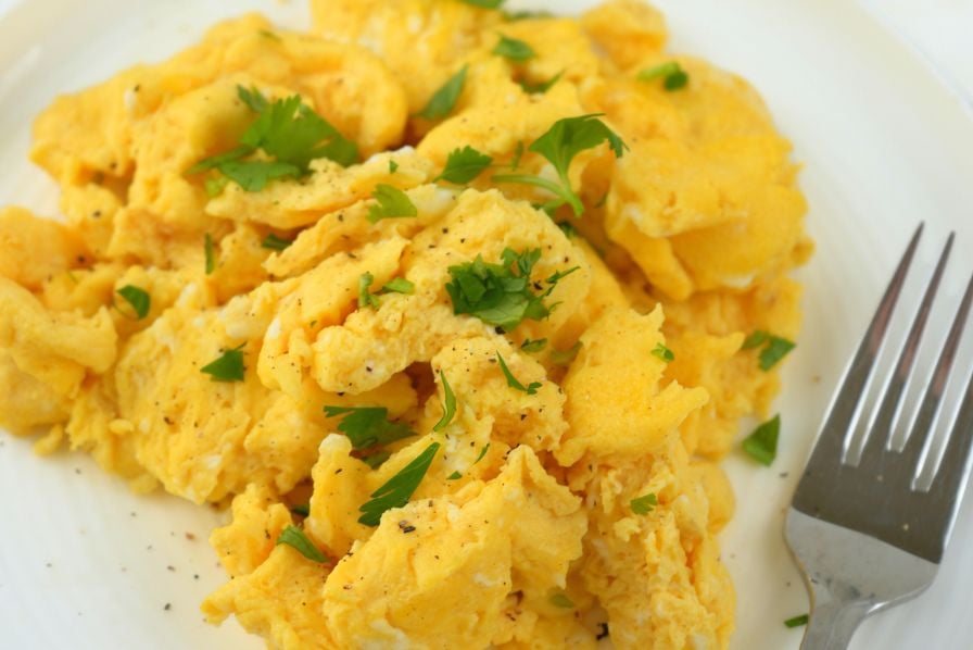 Fluffy scrambled eggs garnished with fresh herbs