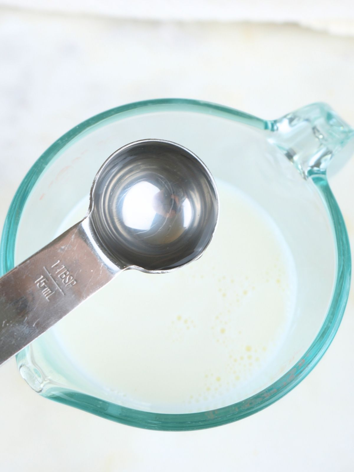 White vinegar being poured into milk