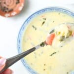 Gnocchi on a spoon over a bowl of creamy gnocchi soup.
