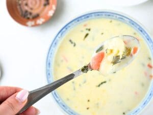 Gnocchi on a spoon over a bowl of creamy gnocchi soup.