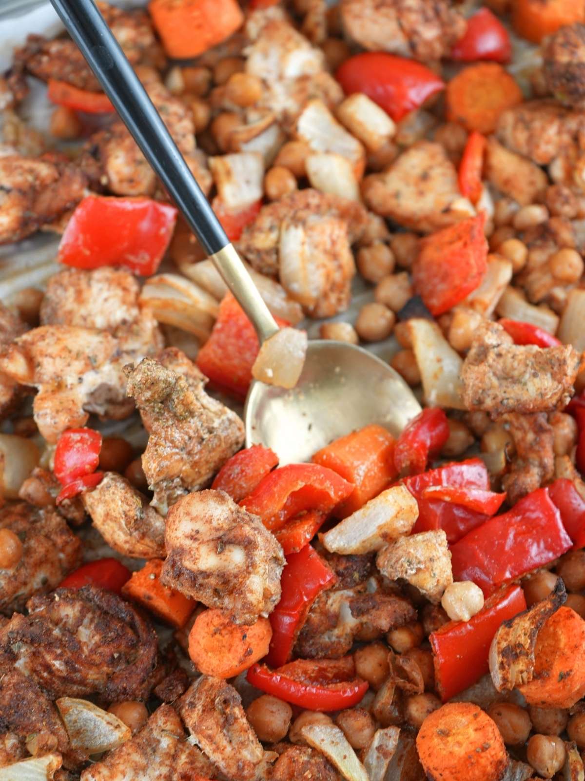 Chicken shawarma sheet pan dinner with a gold serving spoon.