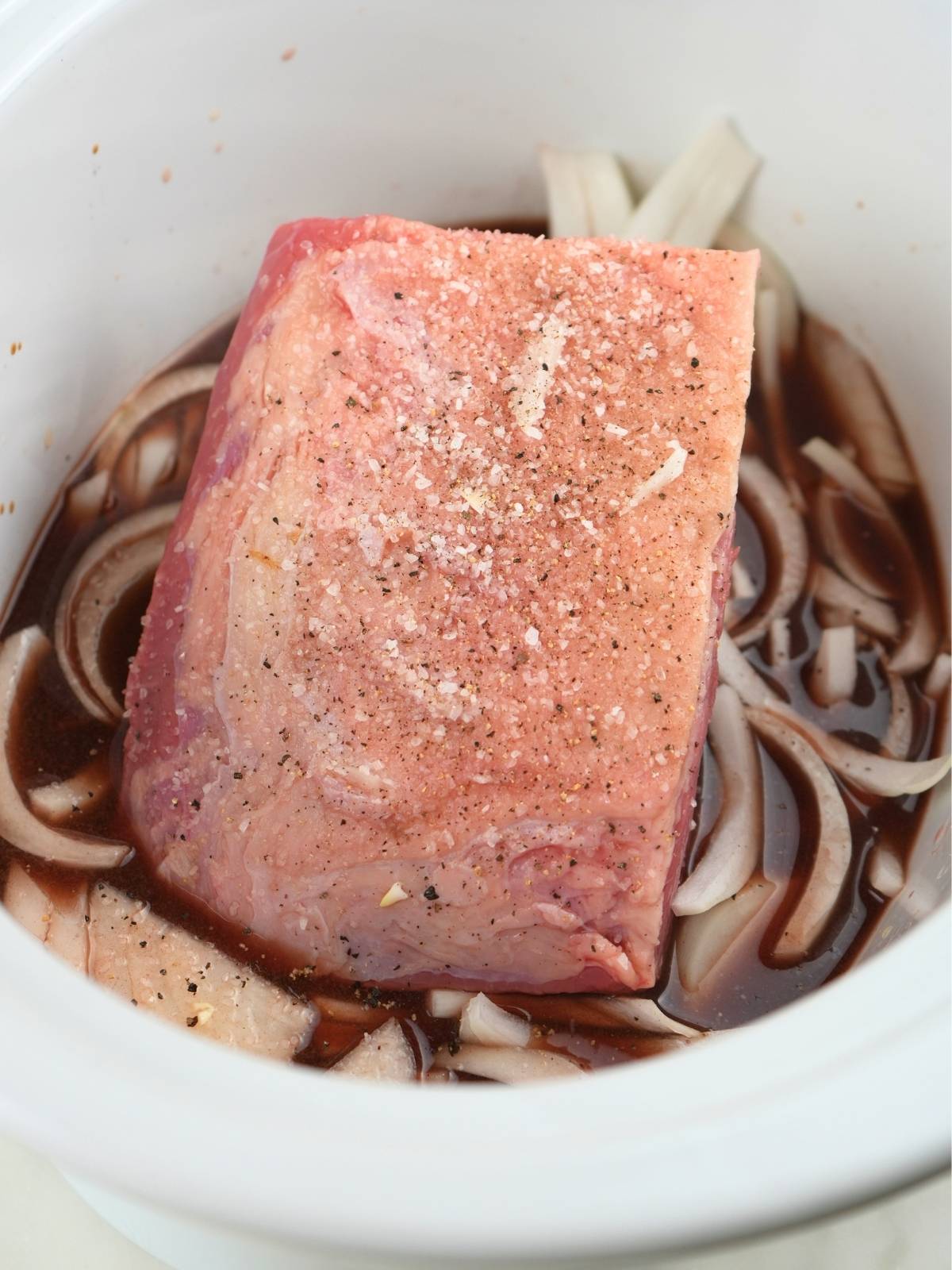 French dip ingredients in a slow cooker insert.
