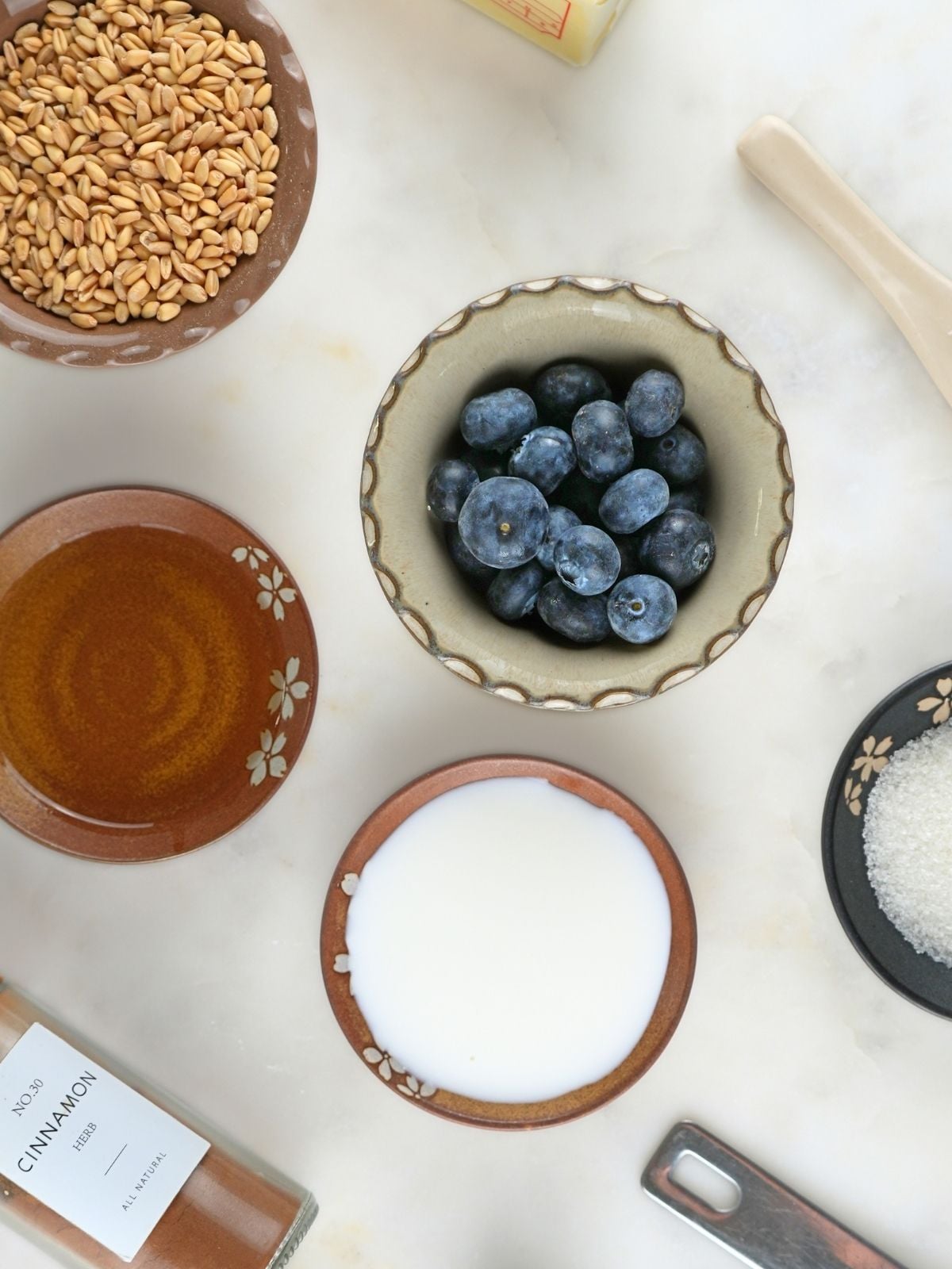 Blueberries and small dishes of baking ingredients on a counter.
