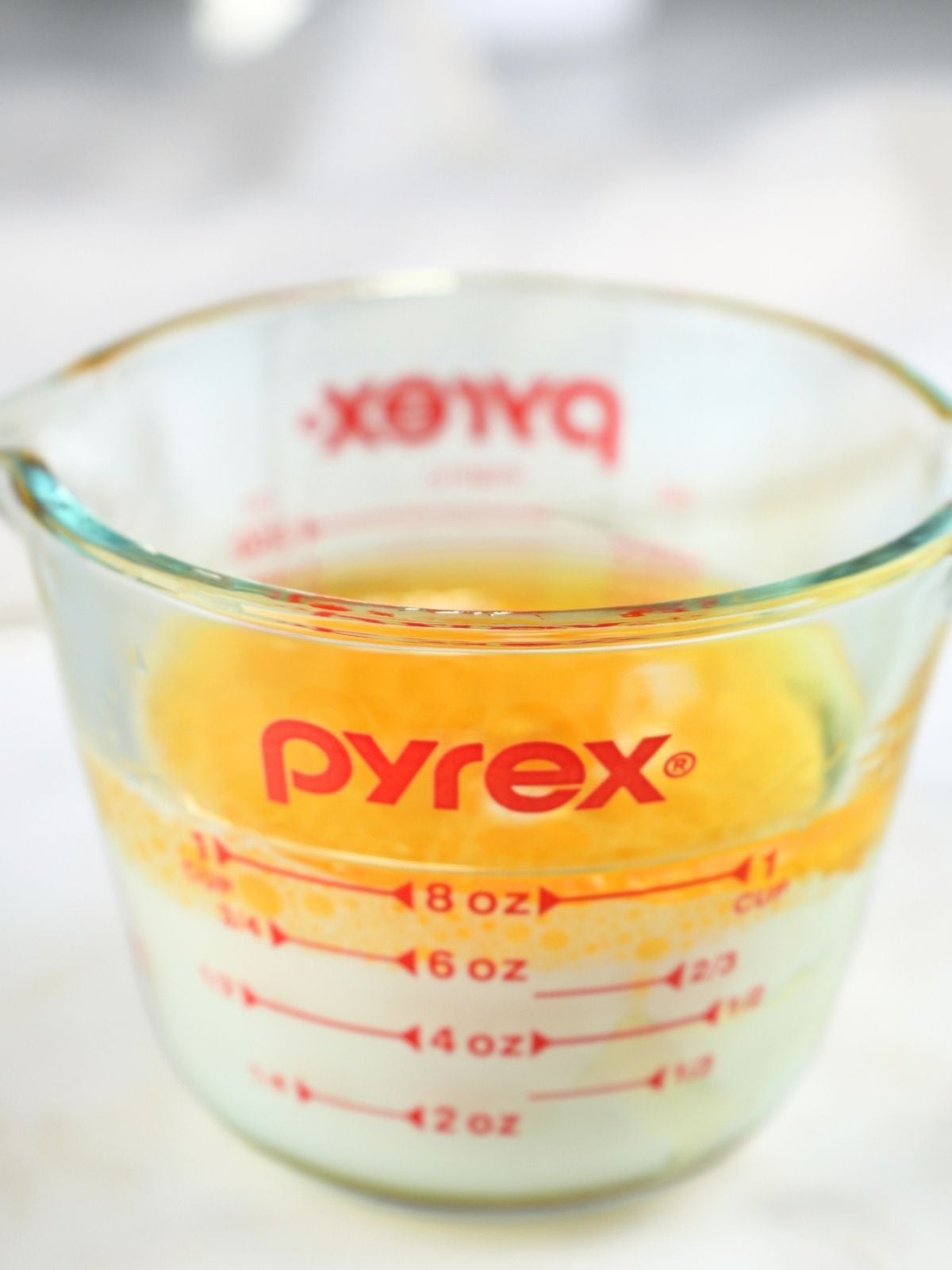 Wet ingredients in a glass measuring cup.