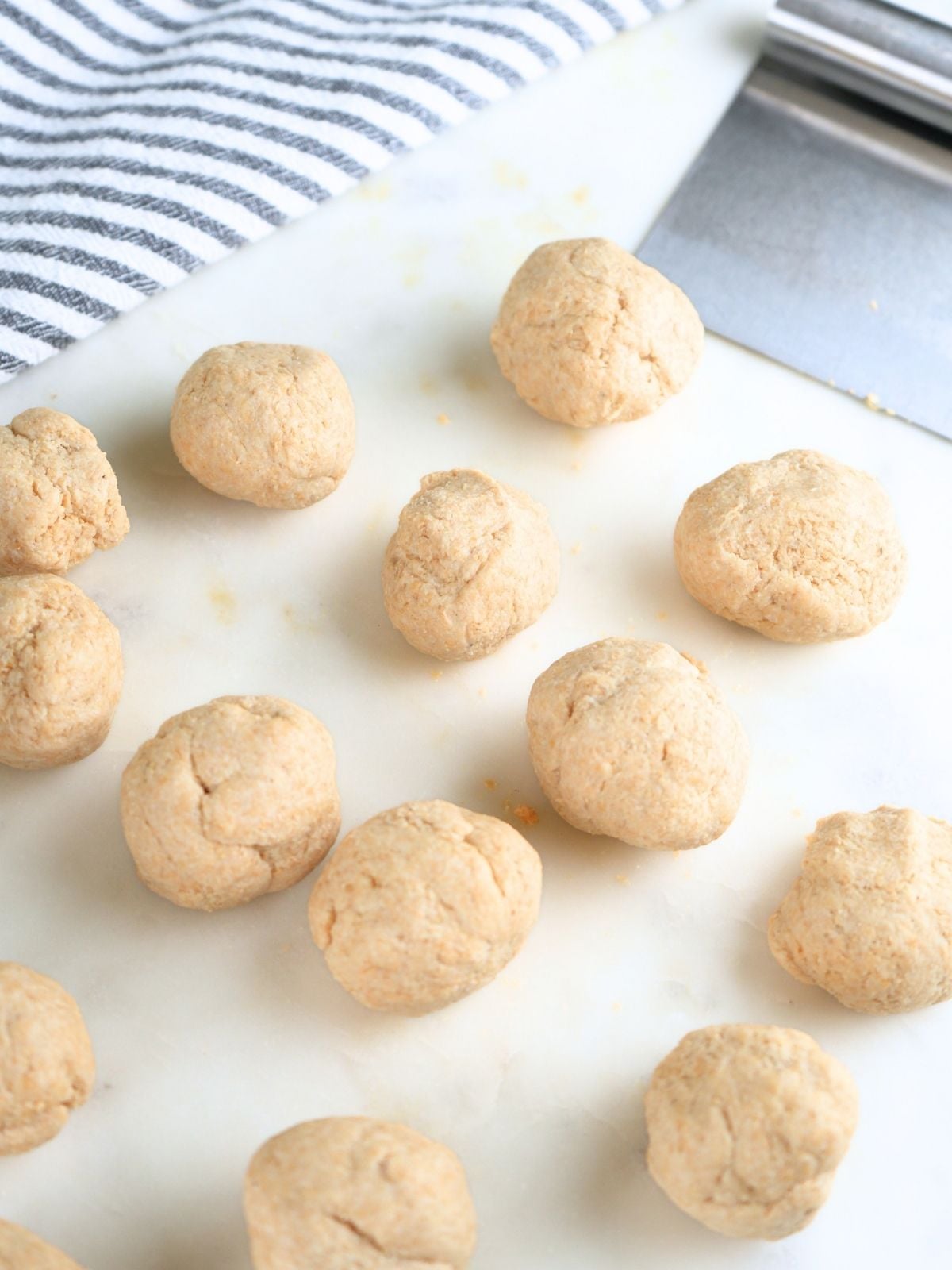 Fresh-milled tortilla dough divided and shaped into balls.