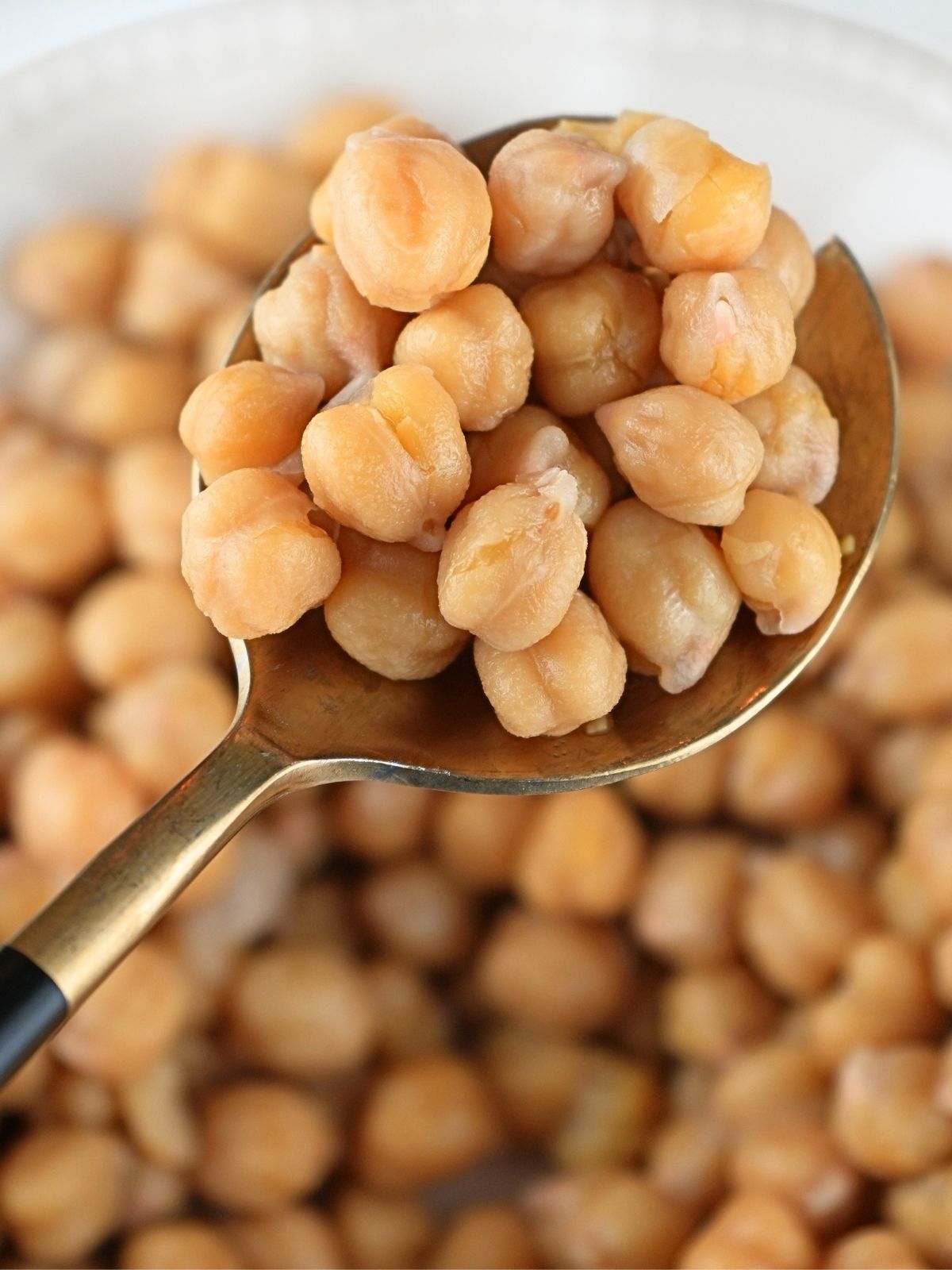 Cooked garbanzo beans on a spoon.