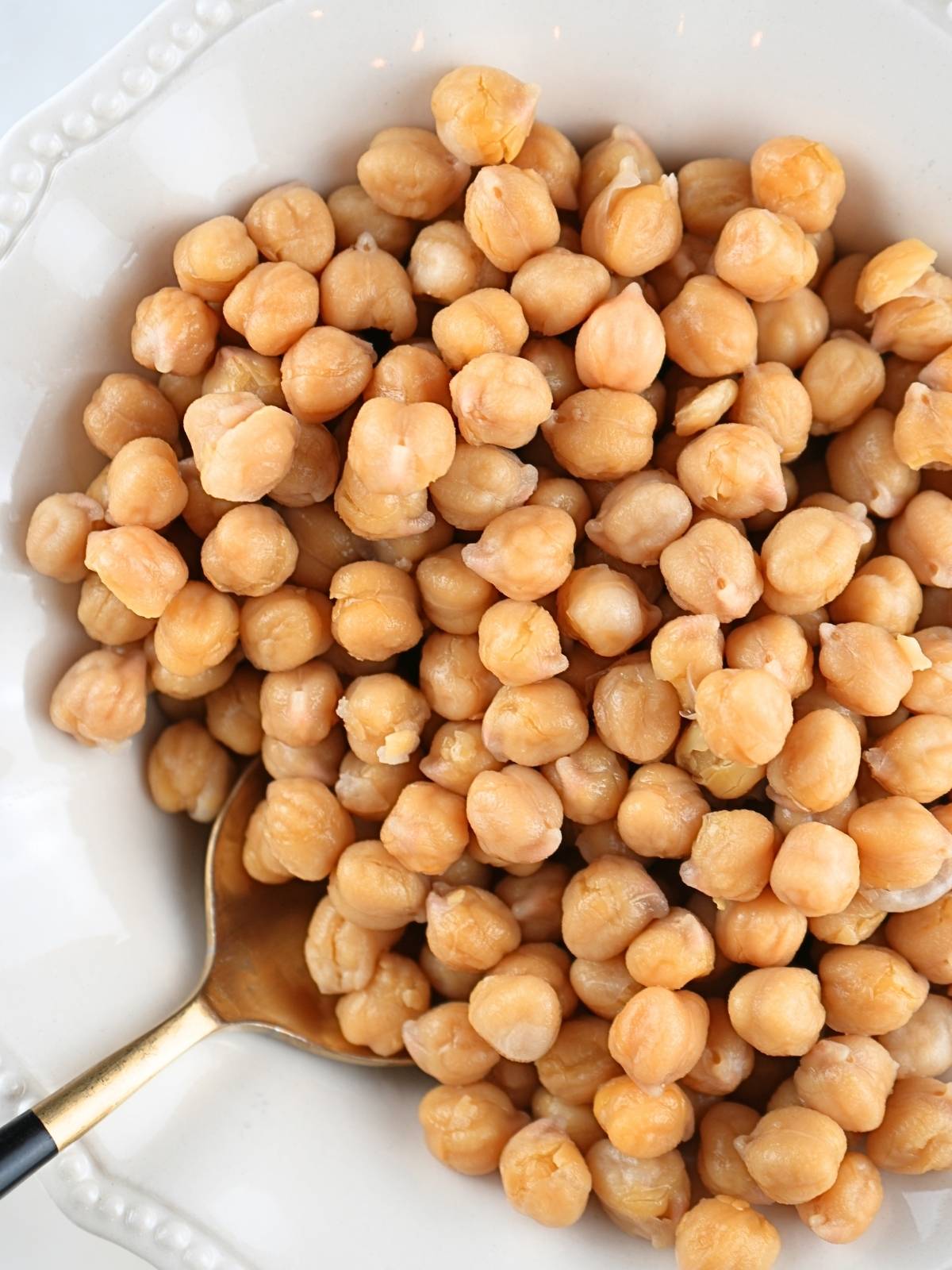 Instant Pot chickpeas piled in a dish with a serving spoon.