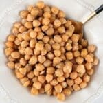 Cooked Instant Pot chickpeas in a bowl with a serving spoon.