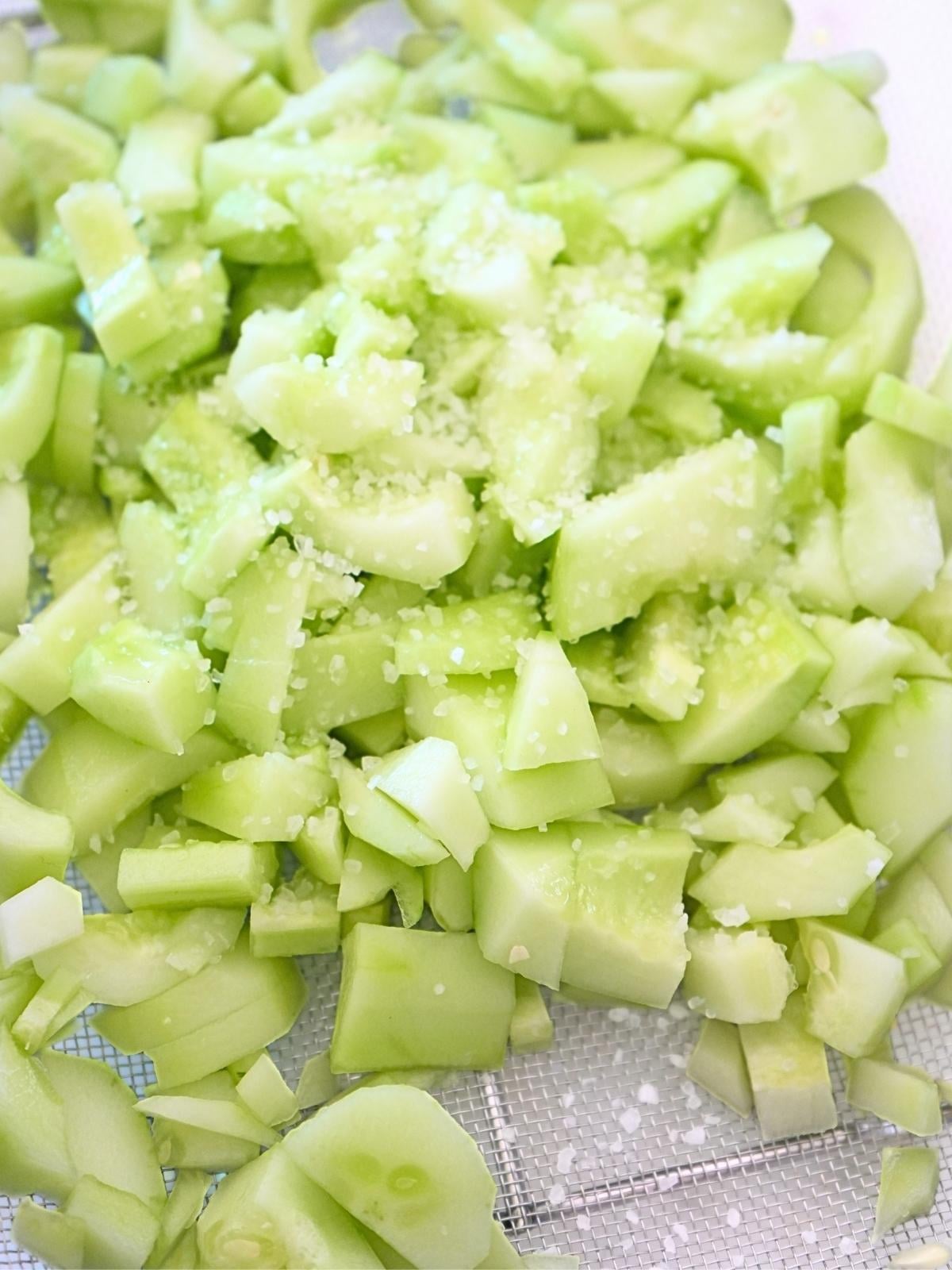 Chopped cucumbers in a colander and sprinkled with salt.