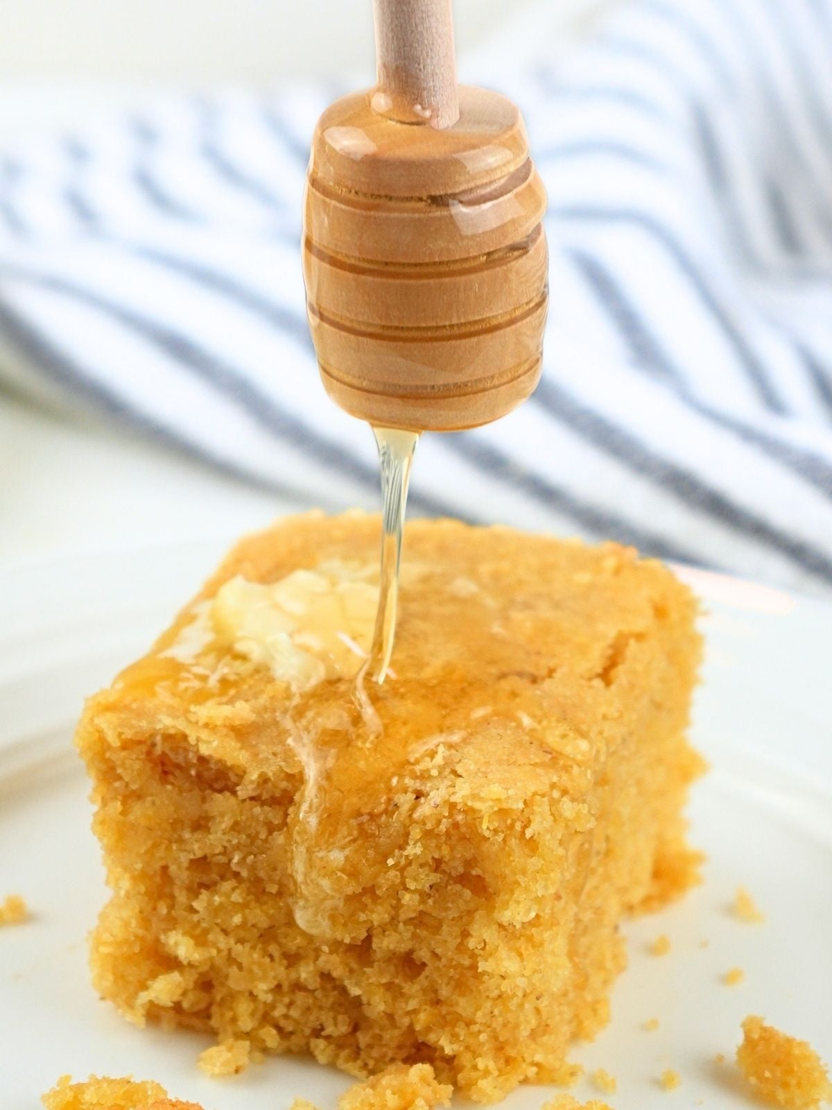 Jalapeño hot honey on a honey stick, drizzling over cornbread.