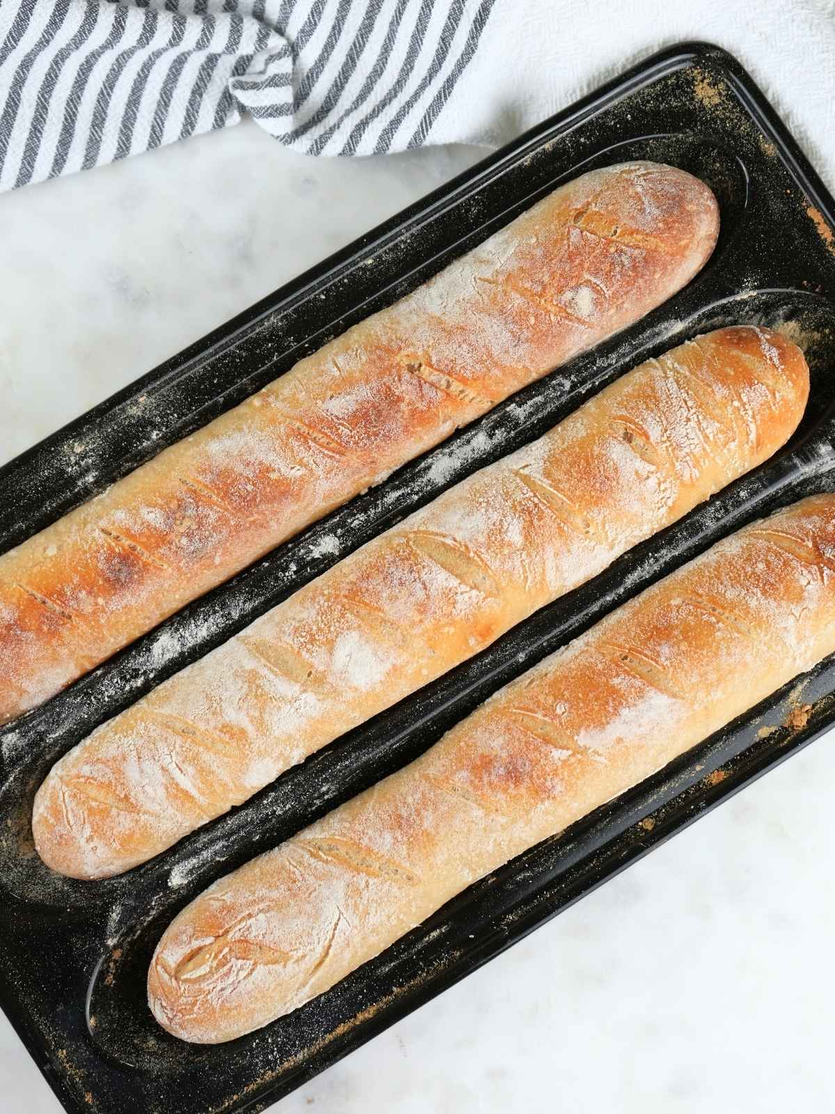 Sourdough baguettes in a baguette pan.