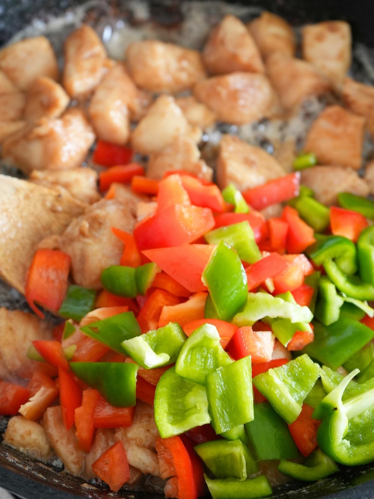 Bell peppers cooking with chicken.