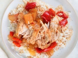 Sweet and sour chicken freezer plated with white rice and black pepper.