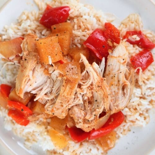 Sweet and sour chicken freezer plated with white rice and black pepper.