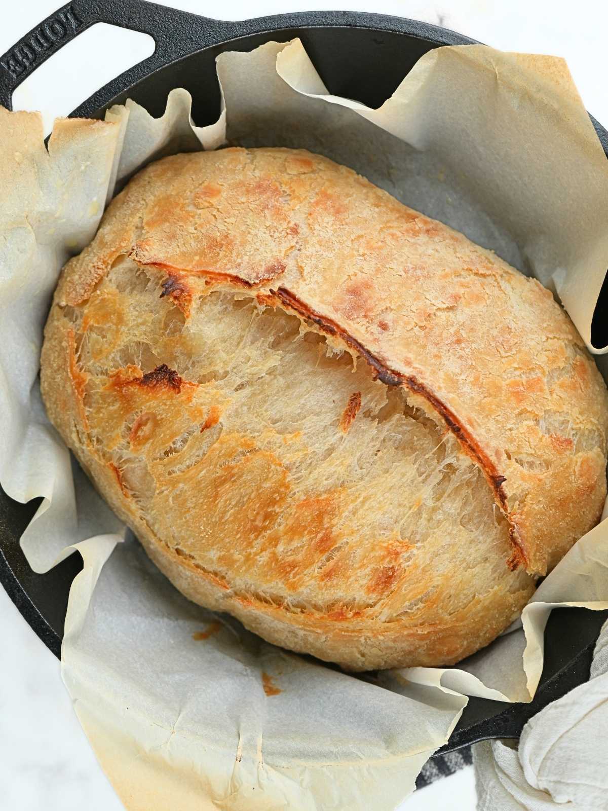 Sourdough croissant bread on parchment paper and in a Dutch oven.