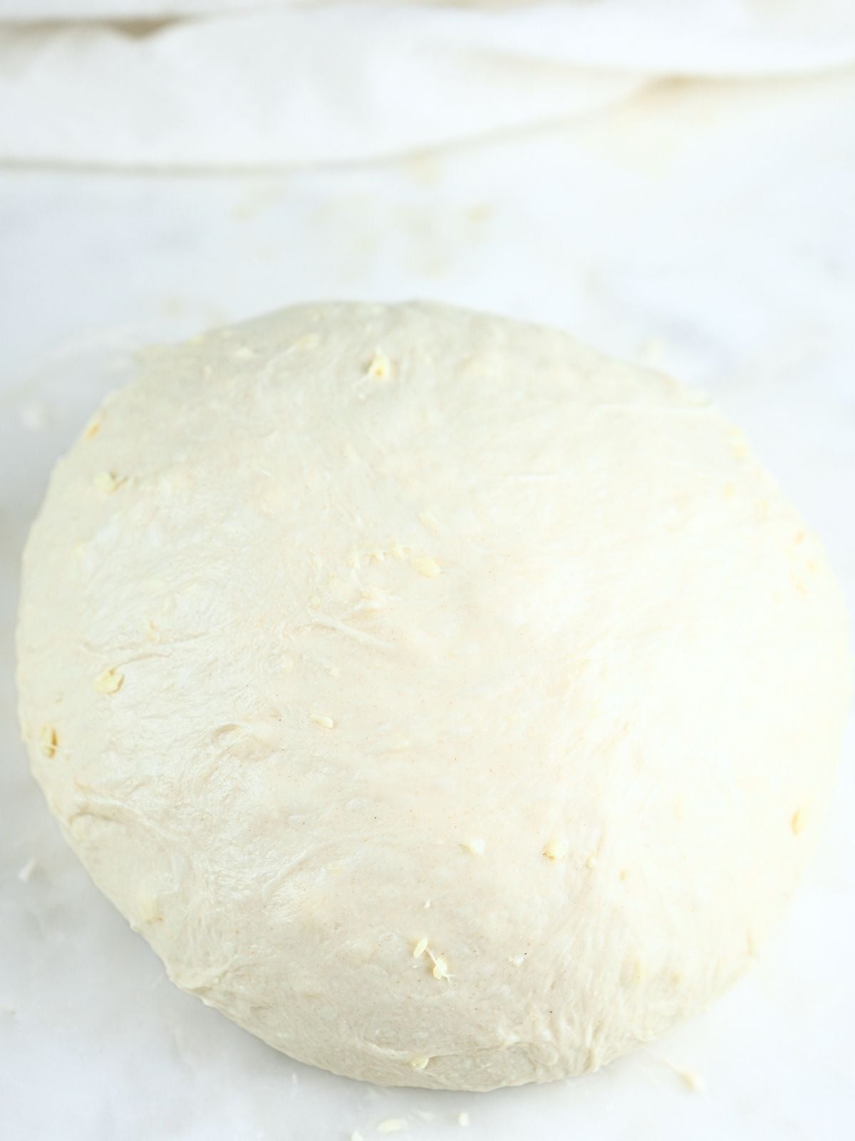 Dough on a counter shaped into a ball.